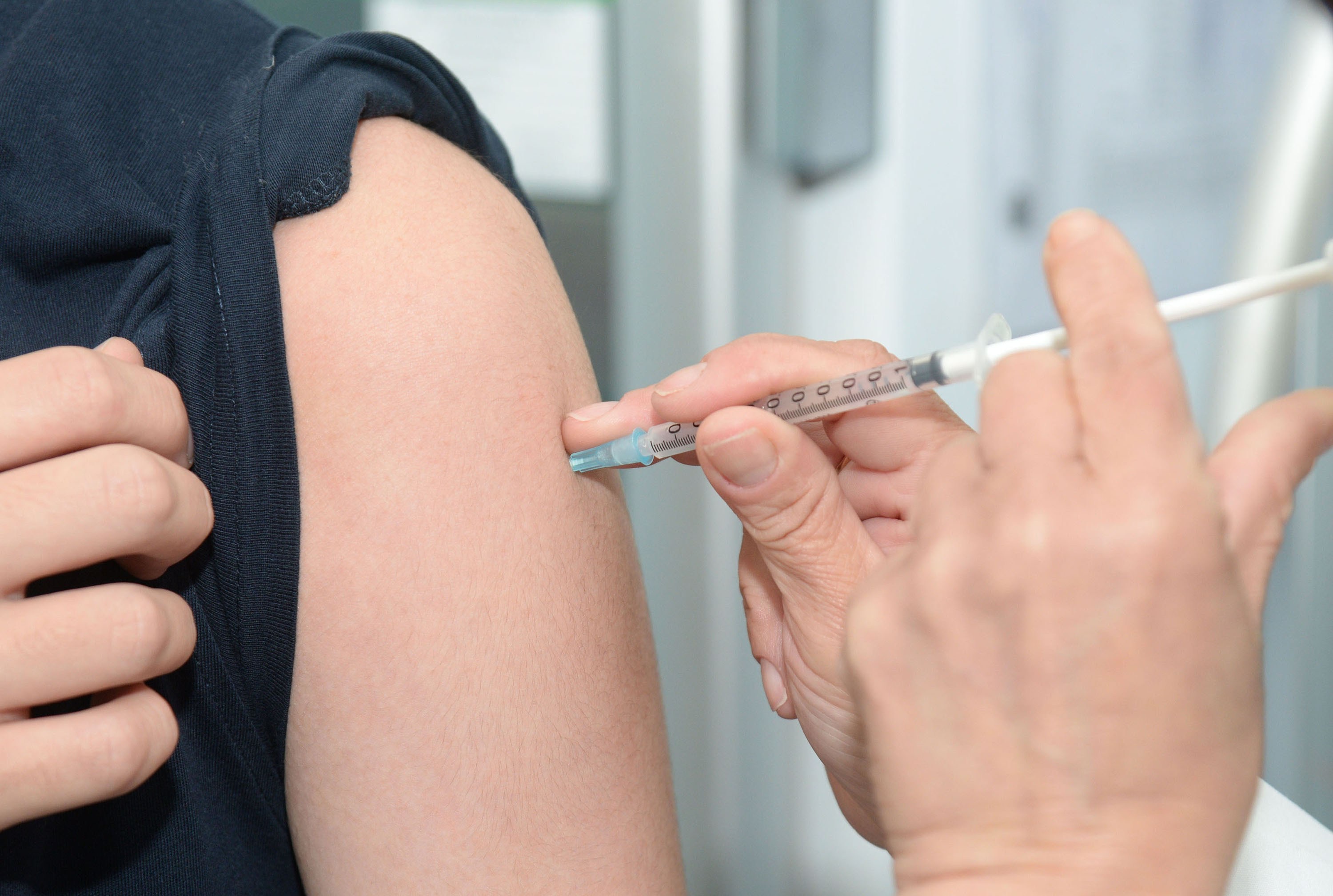 a person receiving an injection on the upper arm