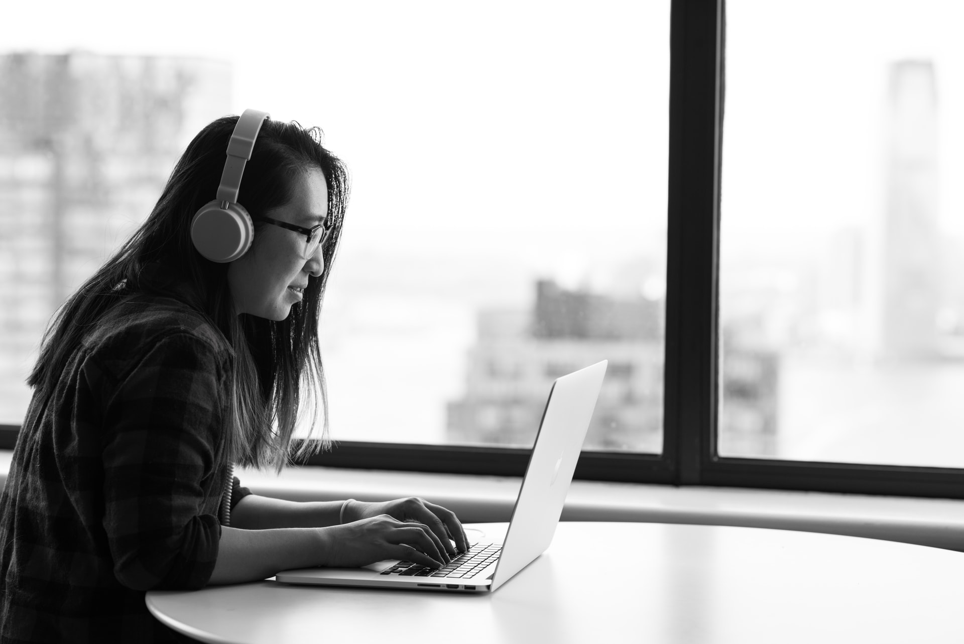 Woman wearing headphones using her laptop