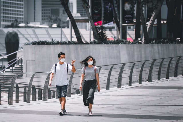 A man and woman wearing masks and walking in Singapore